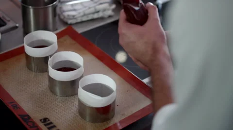 Chef filling chocolate into cases. Stock Footage 64117510