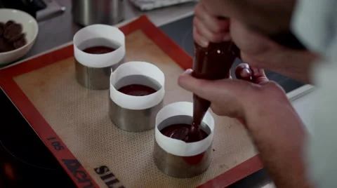 Chef filling chocolate into cases. Stock Footage 64117640