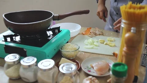 Chef finely chopping fresh garlic cloves for homemade spaghetti recipe Stock Footage 345379611
