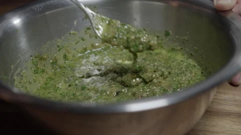 A chef finishes a café de paris sauce. Mixing all ingredients in a metal Stock Footage 254073057
