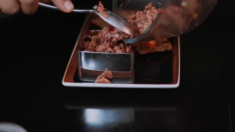 Chef finishes the preparation of the dish spread it on the plate meat in Stock Footage 100304063