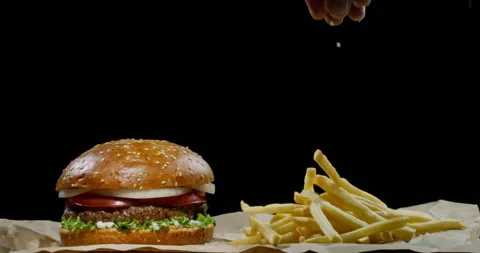 Chef finishing preparing a meal. Close up shot of hand sprinkling hot french Видео 136430626