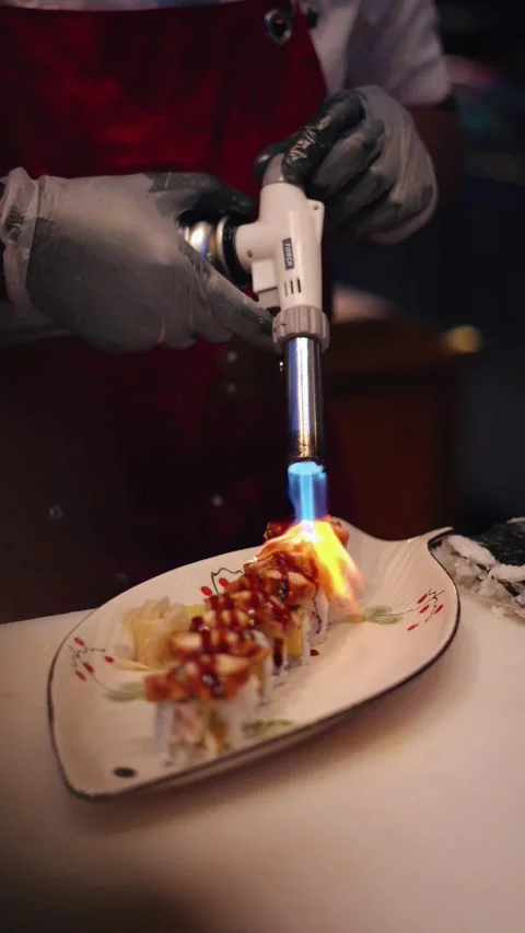 Chef flambeing eel sushi rolls 4K vertical video Stock Footage 317408621