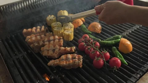 Chef flipping fish and grilled vegetables grilled over an open fire Stock Footage 270728768