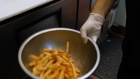Chef flipping flip tosses beer battered fries in metal bowl slow motion- Stock-Footage 89201134