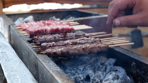 Chef flipping Meat On Skewer Roasting On The Fire Stock Footage 81597244