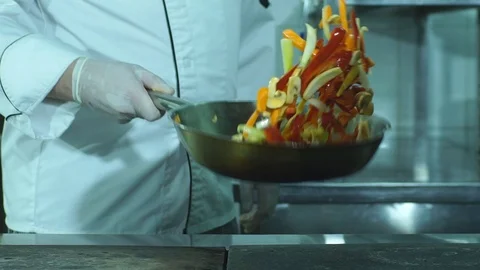 A chef flipping vegetables in a frying pan Stock Footage 71025449