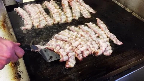 Chef flips bacon Stock Footage 73777978