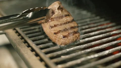 The chef flips the grilled steak Stock Footage 148499423