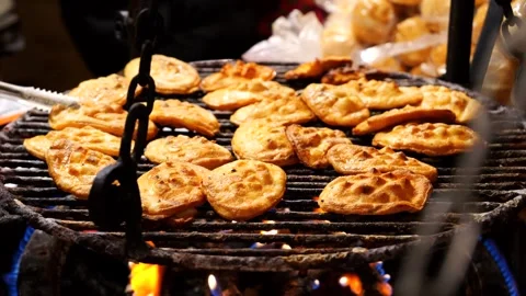 A chef flips Oscypek - Polish regional cheese grilled over fire on a cast-iron Stock Footage 300431253