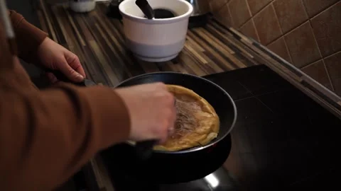Chef flips a pancake baked in a pan with a spatula to the other side Video stock 276053350
