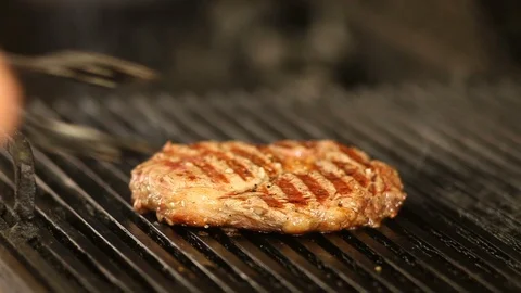 The chef flips the smoky beef steak on the grill.close-up Stock Footage 115821772