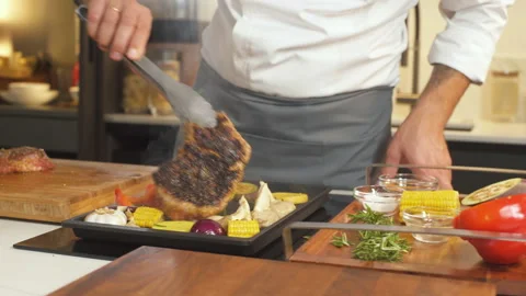 Chef Flips Steaming Steak on Grill Pan At Kitchen. Preparing Delicious Food. 動画素材 142819182