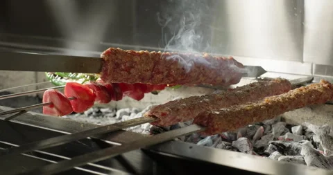 Chef flips traditional Turkish kebab on barbecue grill in a restaurant grilled Stock Footage 263595867