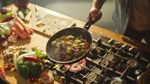 Chef flips vegetables in a frying pan Stock Footage 311835114
