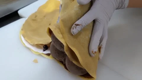 Chef Folding a Fresh Crepe with Chocolate Ice Cream and Strawberries Stock Footage 345692411