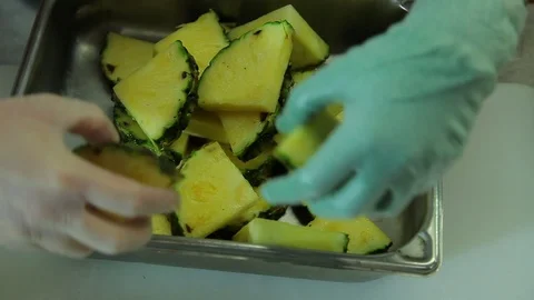 Chef food prep. Moving cut pineapple to container. cu Stock Footage 101700742