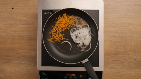 Chef fries carrots, onions and peppers. cooking process. top plan  Video stock 164094341