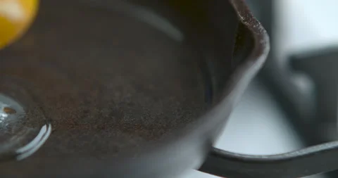 A chef fries an egg, sunny side up, in a small frying pan over an industrial gas Stock Footage 199456490