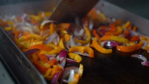 Chef frying and mixing vegetables for the dish on open grill at a restaurant Stock Footage 97886624
