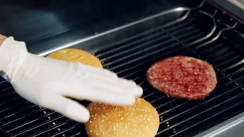 Chef frying buns and cutlet on grill. Cooking meat for hamburger. Stock Footage 158644646