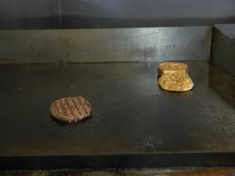 Chef frying burger patty on griddle in commercial kitchen at restaurant 動画素材 73548541