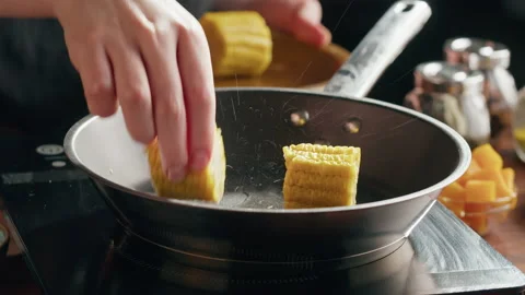 Chef frying corn in pan close-up. Healthy food for vegetarians, roasting Stock Footage 170587212