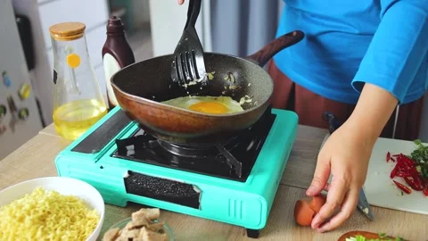 Chef frying egg with chopped shallots and garlic in skillet during meal 库存影片 341487289