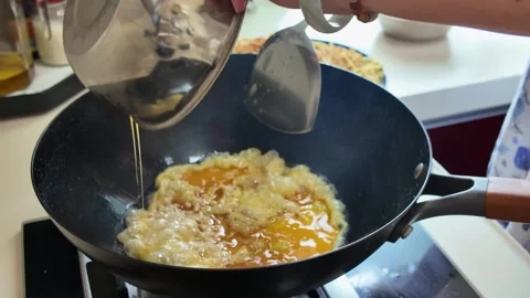 A chef is frying eggs in an iron pan Stock Footage 318729844