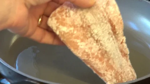 Chef frying fish covered in flour in hot olive oil Stock Footage 72839195