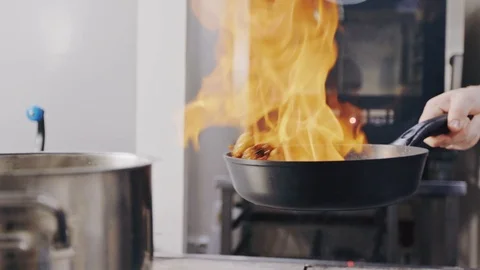 Chef Frying ingridients On Fire Throwing Them In A Frying Pan Stock Footage 104720108