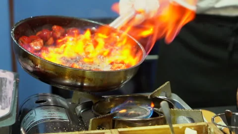 Chef Frying strawberries on fire throwing them in a frying pan. Slow motion Vidéo 162417067