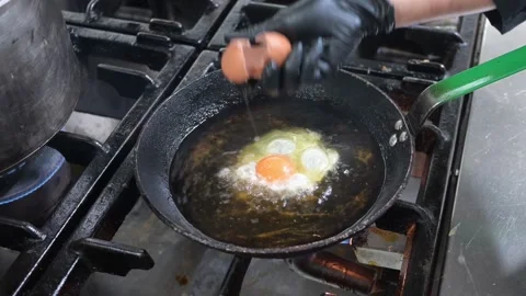 Chef frying two sunny-side up eggs in hot oil Video stock 323353865