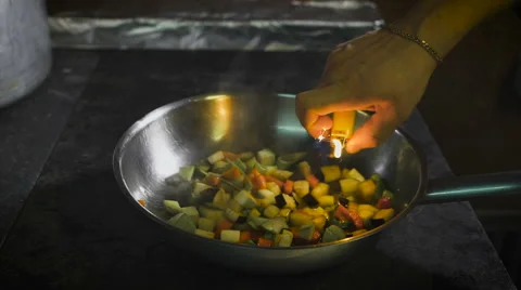 Chef frying vegetables. Cognac is ignited in the pan. Open fire in the kitchen Stock Footage 62484089