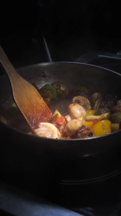 Chef frying vegetables with meat mixing in a frying pan. Chef cooking Stock Footage 309463149