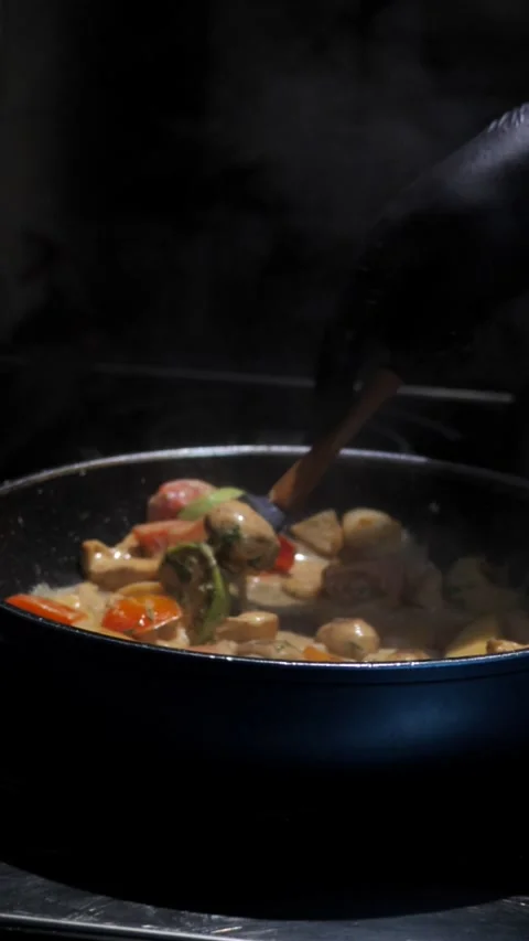 Chef frying vegetables with meat mixing in a frying pan. Chef cooking Stock Footage 309463203