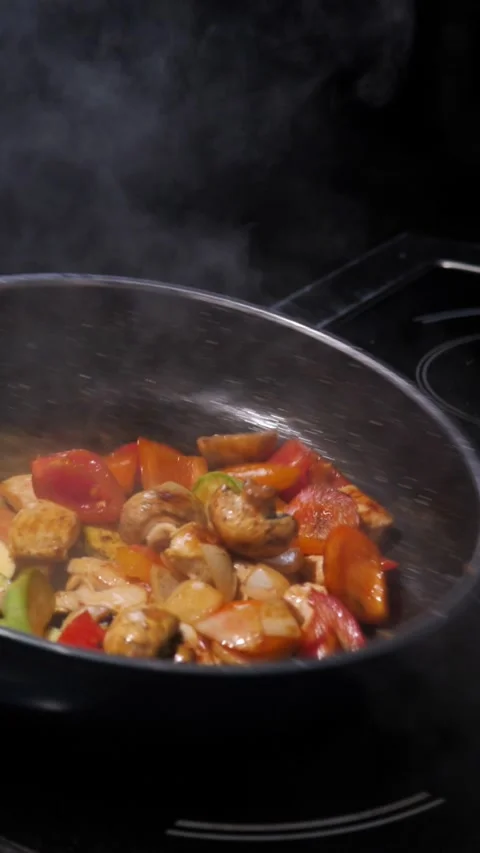Chef frying vegetables with meat mixing in a frying pan. Chef cooking Stock-Footage 309463217