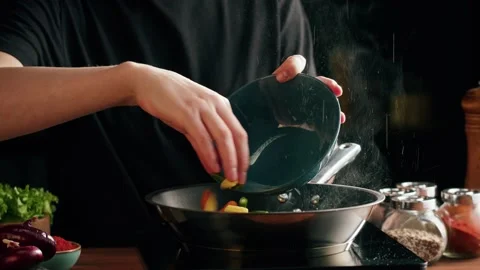 Chef frying vegetables in pan close-up. Woman chief cooking dish with grilled Stock Footage 170326041