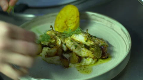 Chef garnishes fish dish with herbs and lemon 库存影片 330976846