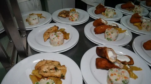 Chef garnishing dinner plates at order station in restaurant Video stock 128359685