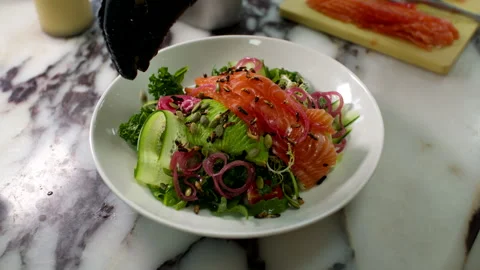 Chef Garnishing Fresh Salmon Salad With Seeds On Marble Kitchen Countertop Stock Footage 337651629