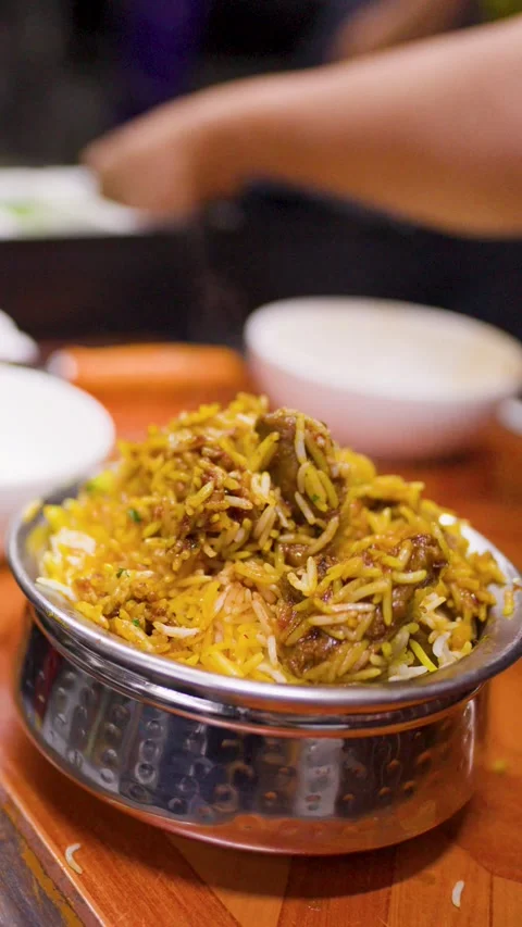Chef Garnishing Hot Steaming Indian Mutton Biryani with Fresh Cilantro Stock Footage 346664433