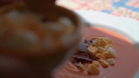 Chef garnishing Salmorejo with boiled egg and jamón  as a finishing touch Stock Footage 246148954