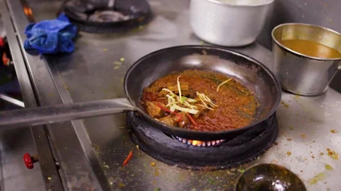 Chef Garnishing Spicy Lamb Curry Simmering in a Commercial Kitchen Pan Stock Footage 346587575