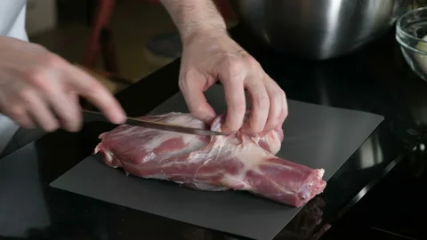 The chef gently slices the leg of the lamb Stock Footage 96379201