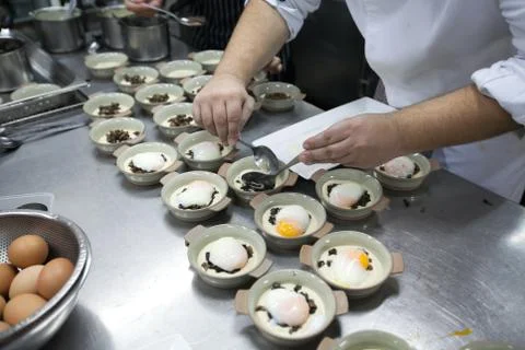 Chef get soft-boiled eggs on white plate put on ceramic bowl Stock Photos