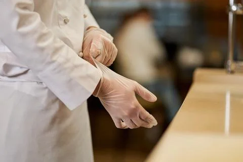 Chef getting ready for work and putting gloves on Stock Photos