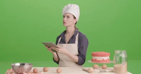 Chef girl whit iPad finding information. Green screen. 4K Stock Footage 170000193