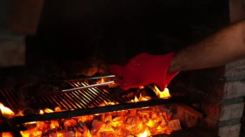 Chef in a glove flips meat on a grill in the oven using tongs Stock Footage 284169144