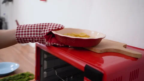 Chef in glove taking baking sheet with baked potatoes and put on oven Stock Footage 316829990